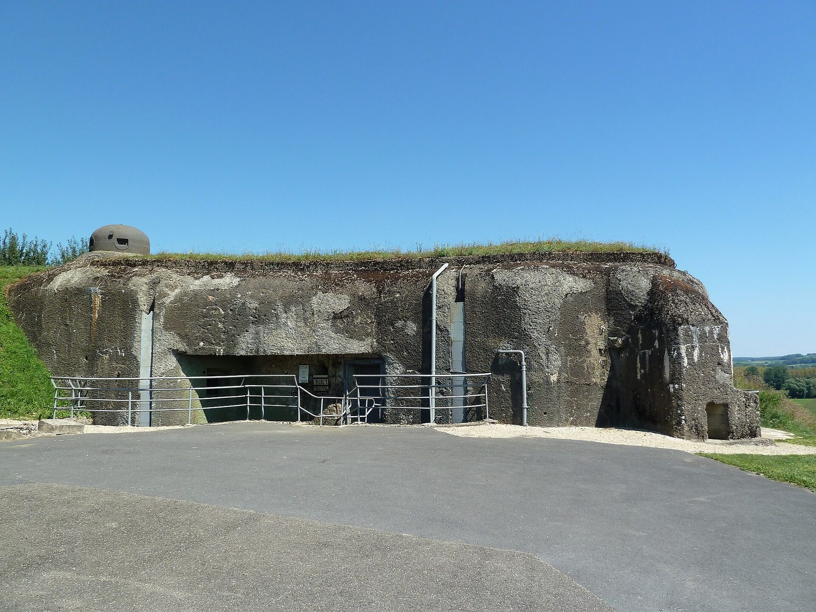 Block 1 of Ouvrage La Ferté as it stands today, a low concrete Maginot Line combat block with an armoured turret set into its roof, on the boundary of Villy and La Ferté-sur-Chiers in the Ardennes