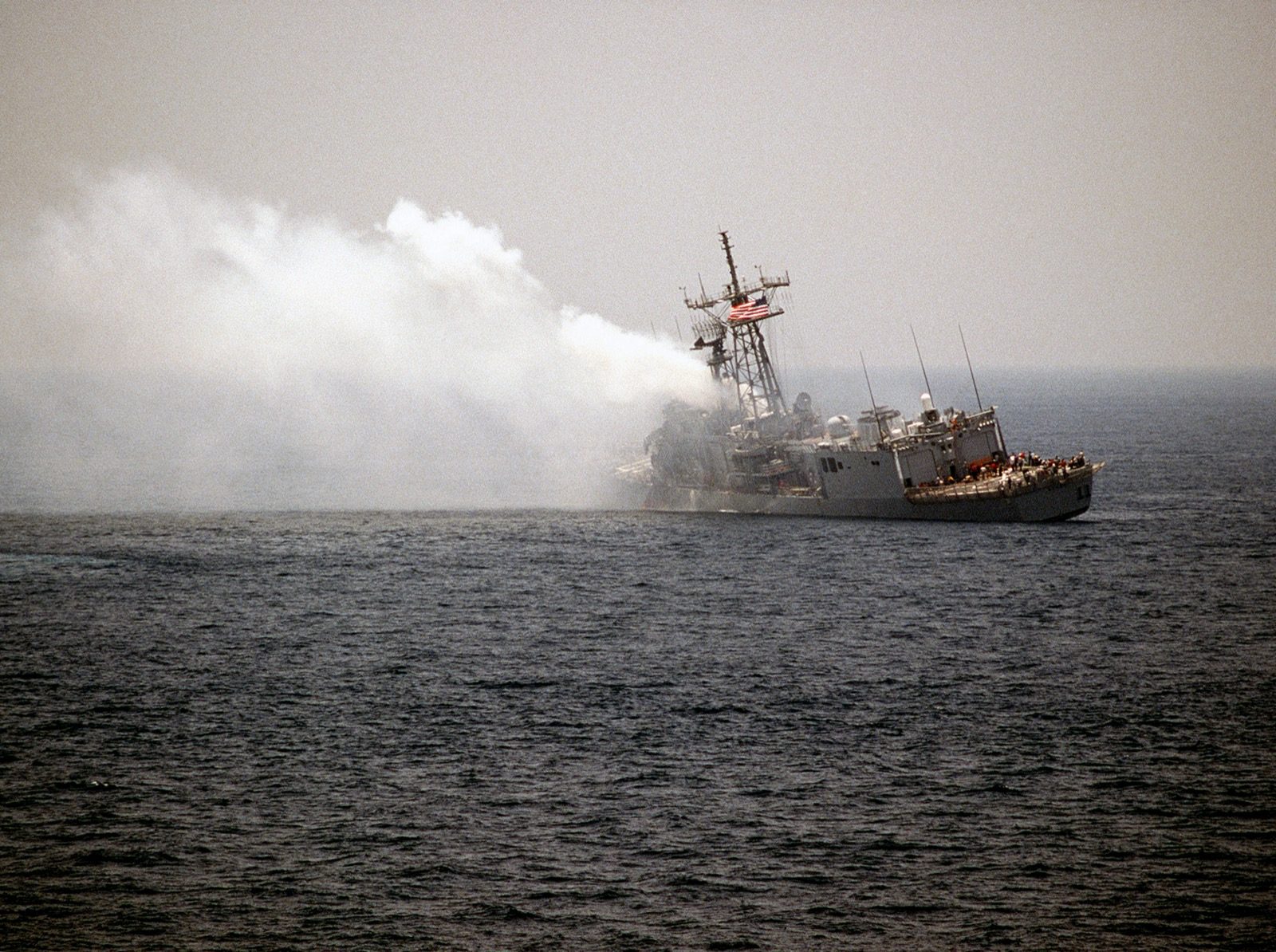USS Stark listing and venting smoke in the Persian Gulf on May 18, 1987, the day after being struck by two Iraqi Exocet missiles that killed 37 sailors