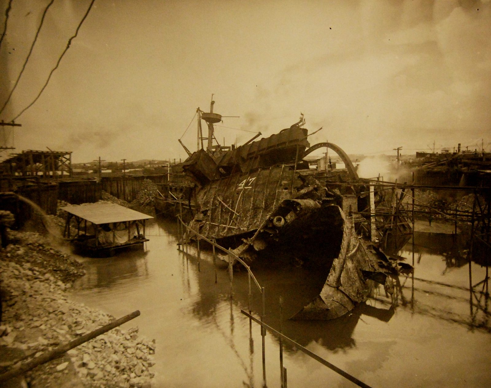 The wreck of USS Maine partially raised inside a cofferdam in Havana harbor during the 1911 Vreeland board investigation