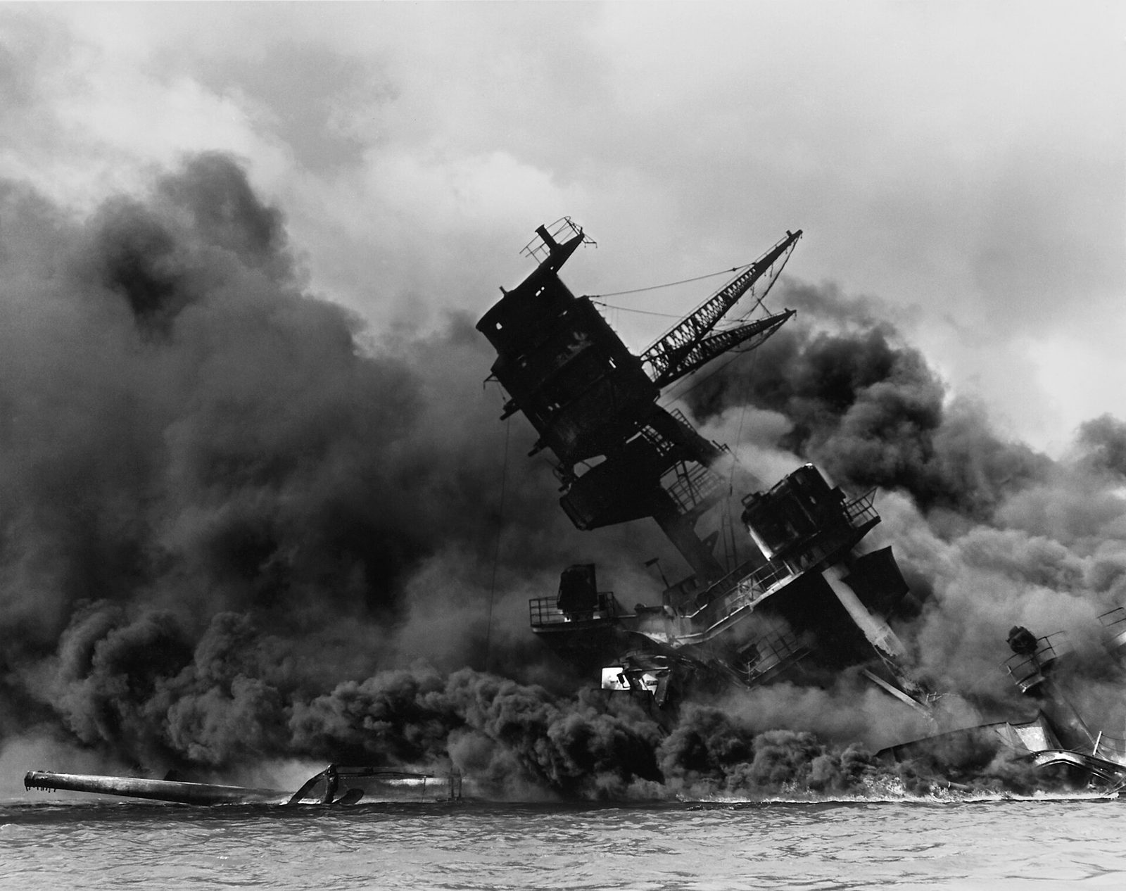 USS Arizona burning and settling on the harbour bottom at Pearl Harbor on 7 December 1941, her forward tripod mast collapsed after the magazine explosion